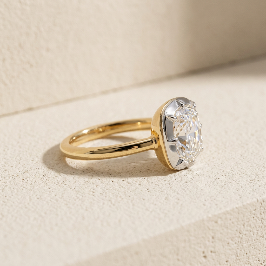 Side profile of the RW pinky dome ring, an elongated cushion-cut diamond low-set in a white gold bezel on a domed 18k yellow gold shank
